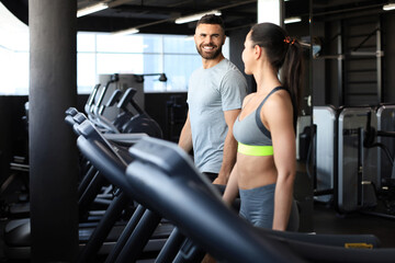 Fototapeta na wymiar Attractive people on the treadmill at sport gym.