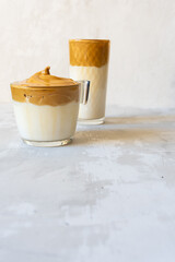 The popular dalgona coffee. Light gray concrete background. Trendy drink from Korea.