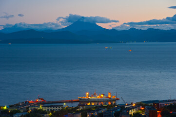 Avachinskaya Bay, a ship in port and a view of the Vilyuchinsky volcano, Kamchatka.