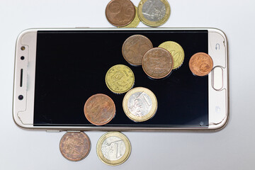 A smartphone with some euro coins over it