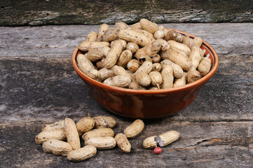 Peanuts in a clay plate. Front view.