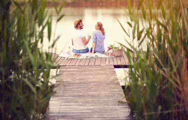 Couple at river enjoying together on romantic picnic.