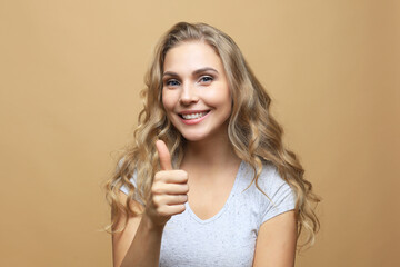 Young happy cheerful woman showing thumb up.