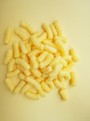 Yellow corn sticks on a yellow background.