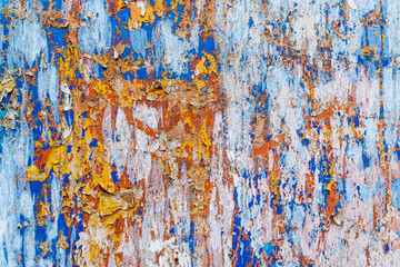 Minimalist colourful textured background of old and rusted whit, blue, brown and orange  paing on metallic surface, in direct sun light in an urban environment.