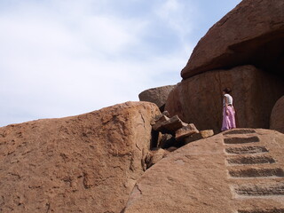 A woman descends to the stone observatory in the Hampi ruins, Hampi, Karnataka, South India, India