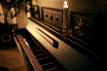 vintage piano with candelabra. burning candles © Denys