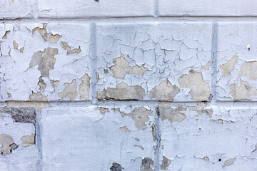Grey grunge concrete brick background with a cracked peeling top coat of paint.