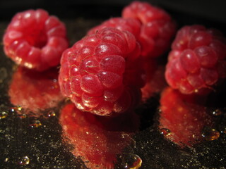 Ripe raspberries on a golden background close up