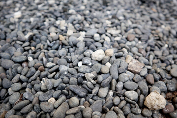 Landscape background photo of natural small round and ellipse grey rocks / stones with smooth textures for aquarium or garden sidewalk decoration