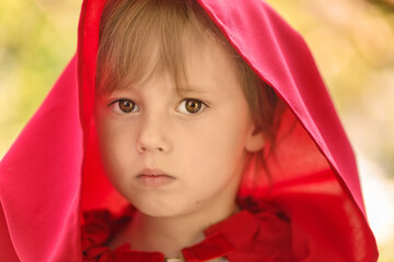 Close-up portrait of a girl in a fabulous costume of Little Red Riding Hood