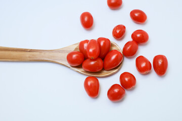 View from above of tomato cherry in the wooden spatula on white background 
