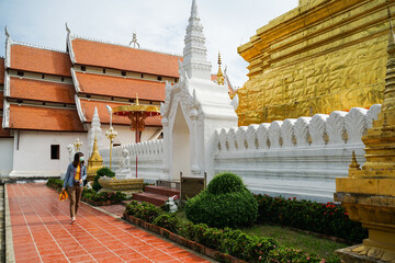 Young asian woman tourist wearing medical mask come to visit Wat Phra That Chae Haeng Temple,...