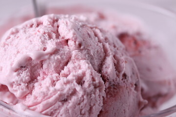 tasty cold melting strawberry and raspberry icecream in a glass container. close up shot.