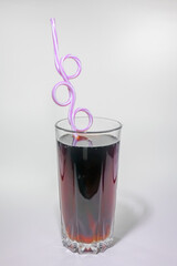 soft drink in a glass with a straw on a light background