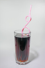 soft drink in a glass with a straw on a light background