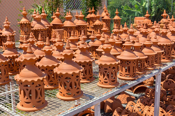 Many orange clay lanterns outside at pottery