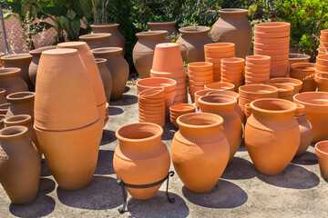 Many orange clay vases outside at pottery