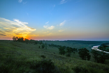 Beautiful sunrise over the hill and the river at the bottom.