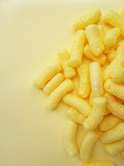 Yellow corn sticks on a yellow background.