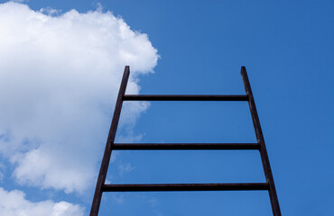 A stairway leading up to blue sky with sun over light cloud. Ladder of success.
