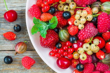 Fresh organic berries on a plate on a wooden table