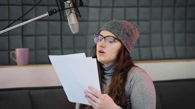 A female voice actor recording animated voices into a professional microphone