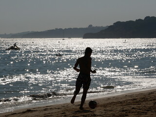 Chłopiec, który gra w piłkę na wybrzeżu w Portugalii