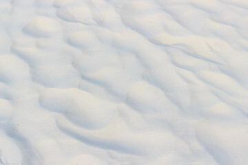 Wavy texture of white sand, background