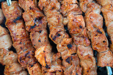 skewered pork kebab grilled over charcoal, smoke over a barbecue, medium cooking, close