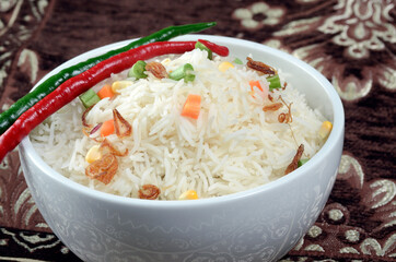 bowl of cooked basmati garnished with chopped vegetables in even lighting