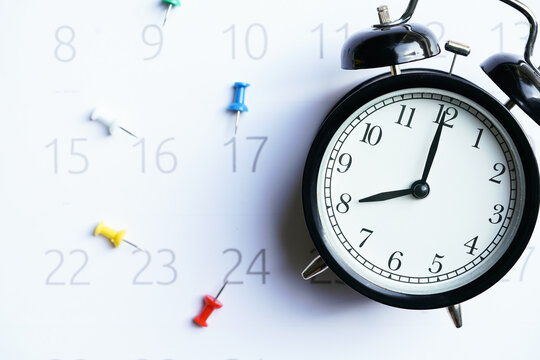 close up of alarm clock and calendar on the table, planning for business meeting or travel planning concept