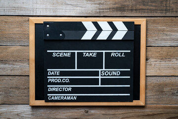 Fototapeta na wymiar movie clapper on wood table background ; film, cinema and vedio photography concept