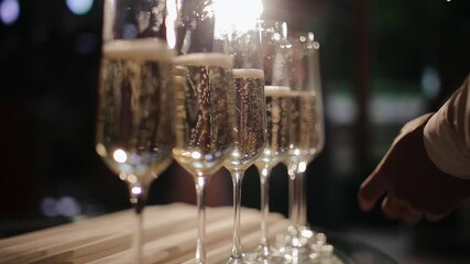 Waiter is pouring champagne. Pour the champagne into a glass. Bartender pouring champagne into glass, close-up. Champagne pouring in glass. - Powered by Adobe