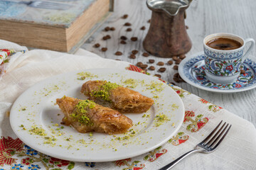 Turkish coffee and Traditional Turkish dessert baklava in plate on wooden table