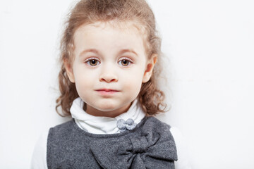 Cute little girl with curly hair on a white background. Close-up.