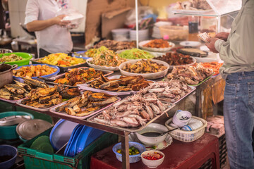 fruits, flowers and fish for sale at a market
