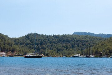 Fototapeta na wymiar A large body of water with boats and a hill covered with trees
