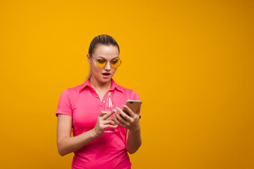 A healthy lifestyle, drink water and use the app for fitness tracking. A young woman with a bottle of clean water