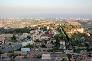 Fototapeta premium aerial view of Gerace, Calabria (Italy) at the sunset on a hill. A south italian village. it is possible see the stone houses and the wood around them. 