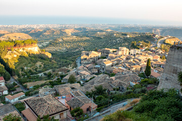 aerial view of Gerace, Calabria (Italy) at the sunset on a hill. A south italian village. it is possible see the stone houses and the wood around them. 