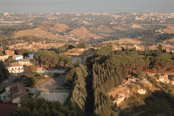 Obraz premium aerial view of Gerace, Calabria (Italy) at the sunset on a hill. A south italian village. it is possible see the stone houses and the wood around them. 