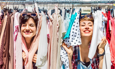 Happy women at weekly flea market - Female friends having fun together shopping cloth on sunny day...