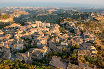 aerial view of Gerace, Calabria (Italy) at the sunset on a hill. A south italian village. it is possible see the stone houses and the wood around them. 