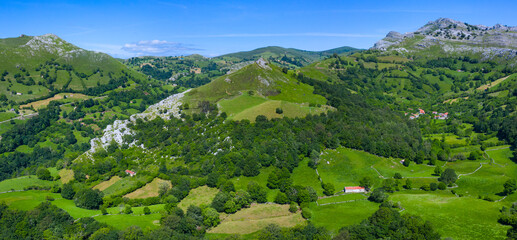 Spring landscape of mountains, meadows of mowing and cabins pasiegas in the Miera Valley, Cantabria, Spain, Europe