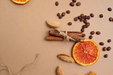 Fototapeta na wymiar Citrus and spicy background with coffee beans and spices, warm ochre background