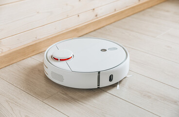 Wireless robot vacuum cleaner working on the floor. Smart household technologies.
