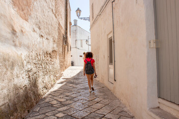 Fototapeta na wymiar Old town of Ostuni during a sunny day, the white village. It is a turistic destination in Puglia ( apulia) in the summer. The city is in white stone bricks and is very old ( medieval time).