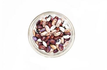 All kinds of kidney beans in a small glass bowl isolated on white background. Top view
