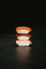 stock photo of varied japanese sushi with different flavors on black background